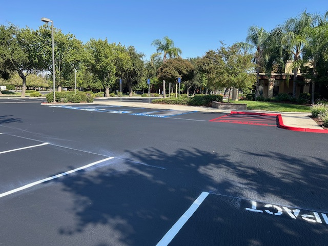 ADA compliant blue handicap parking stalls with cross-hatching and red fire lane curb painting at a commercial property in the Central Valley