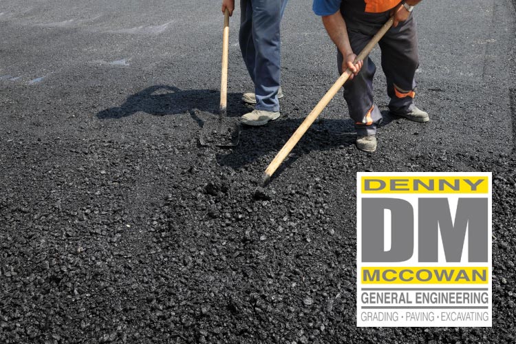 Professional crew members actively spreading and leveling fresh, hot black mix during an asphalt paving and installation project by Denny McCowan General Engineering.