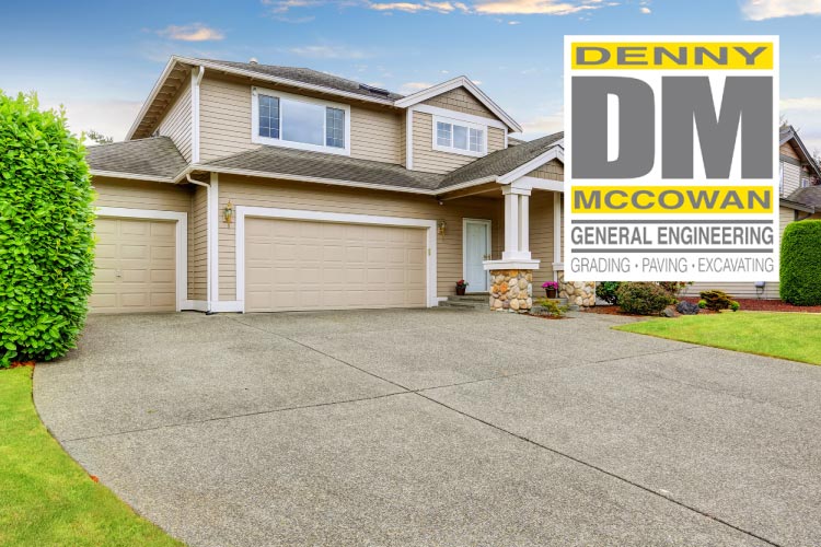A beautifully paved, pristine concrete driveway leading to a modern two-story residential home, showcasing the flawless grading and paving solutions provided by Denny McCowan General Engineering.